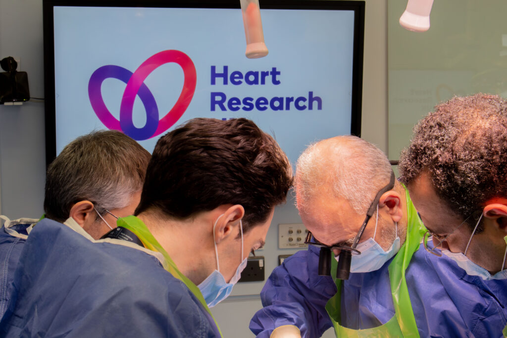 Heart Research UK Masterclass Clinicians at work with Heart Research UK logo on white TV screen in the background