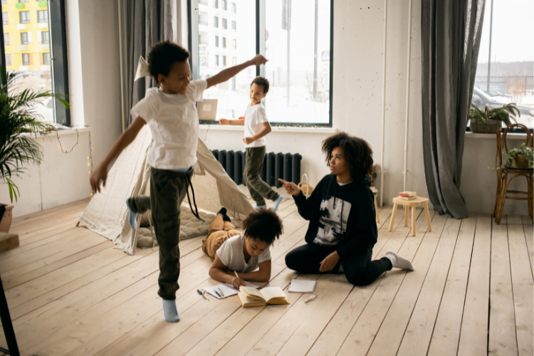 Getting active 2 woman and three children playing indoors with a tee-pee tent