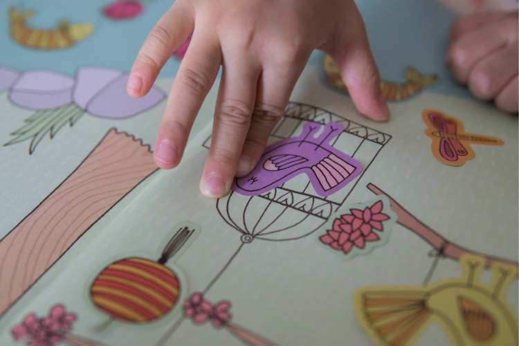 Influencing childrens eating 1 Child's hand placing sticker in a sticker book