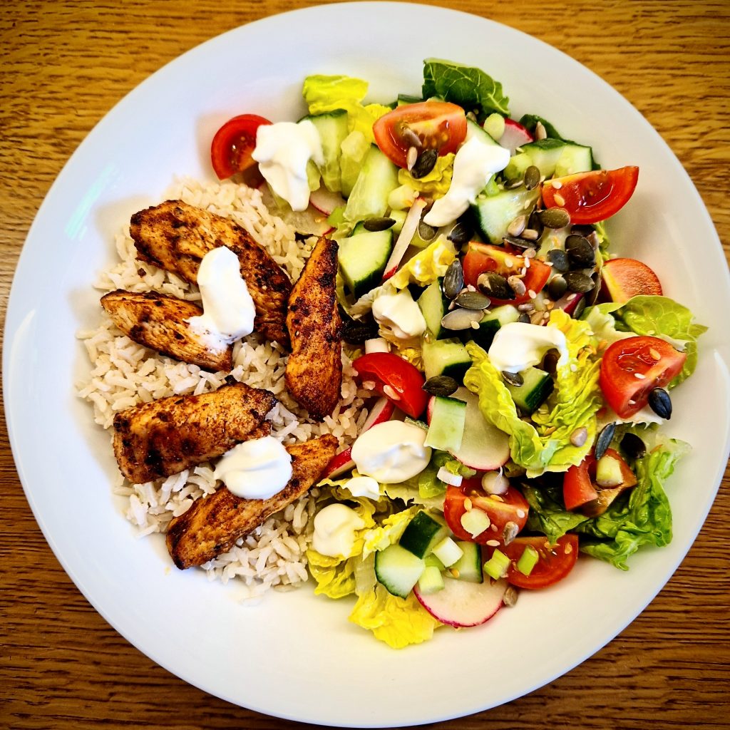 bowl of salad with spicy chicken pieces