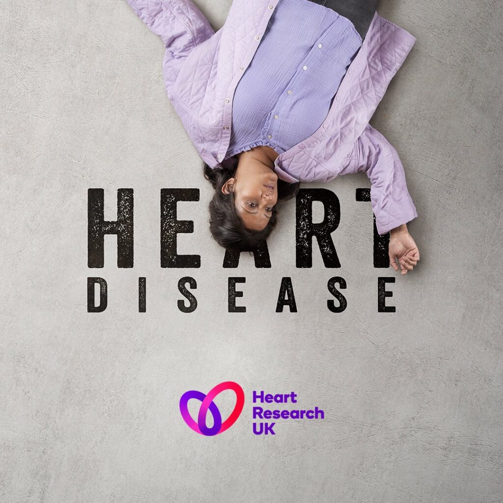Asian female lying on the floor covering the word 'Heart Disease' so it spells out 'HER Disease'