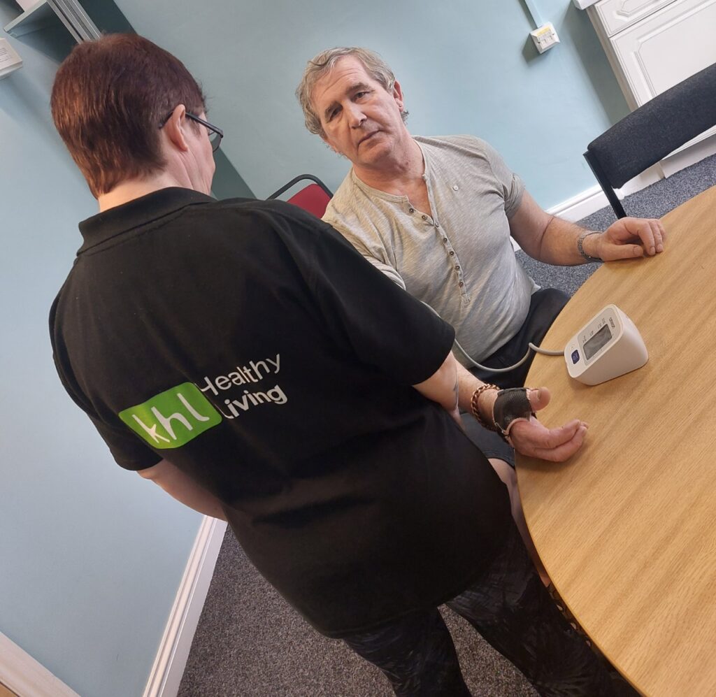 Keighley Healthy Living project: Staff giving a white male a blood pressure check