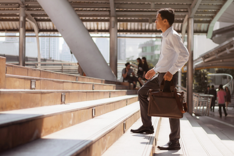 person walking up stairs with briefcase