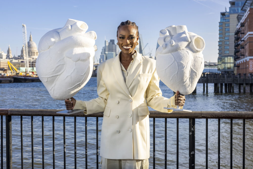 Celebrity chef Lorraine Pascale holds hearts made entirely of sugar, representing the UK recommended allowance vs what the average Brit consumes in a year – 10,950 grams vs 20,075 grams - a difference of 83% more.