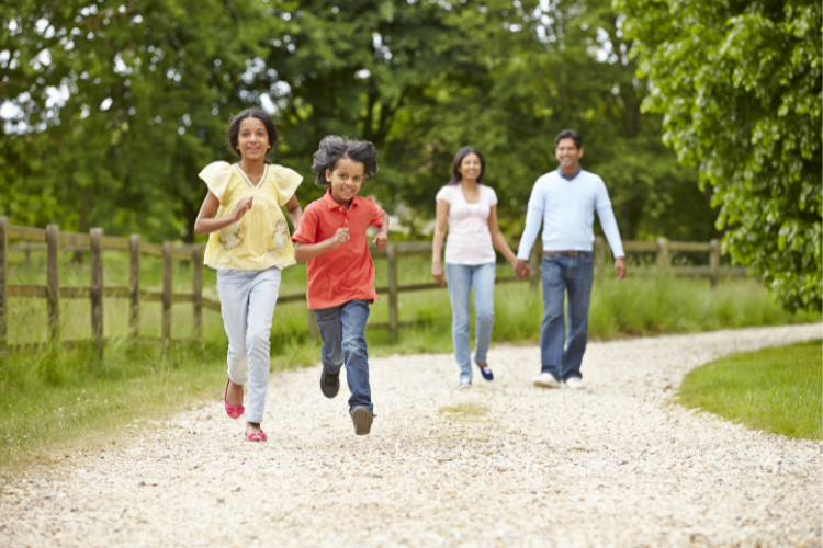 003 an asian family of two parents walk in the countryside with their two children ahead of them walking regularly can contribute to heart health