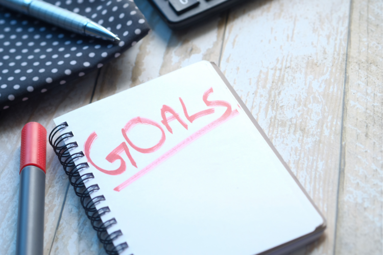 01 a notepad with the word goals written largely in the colour red