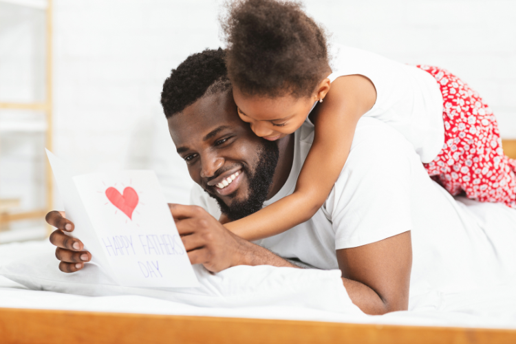 a-father-and-daughter-cuddling-reading-a-fathers-day-card