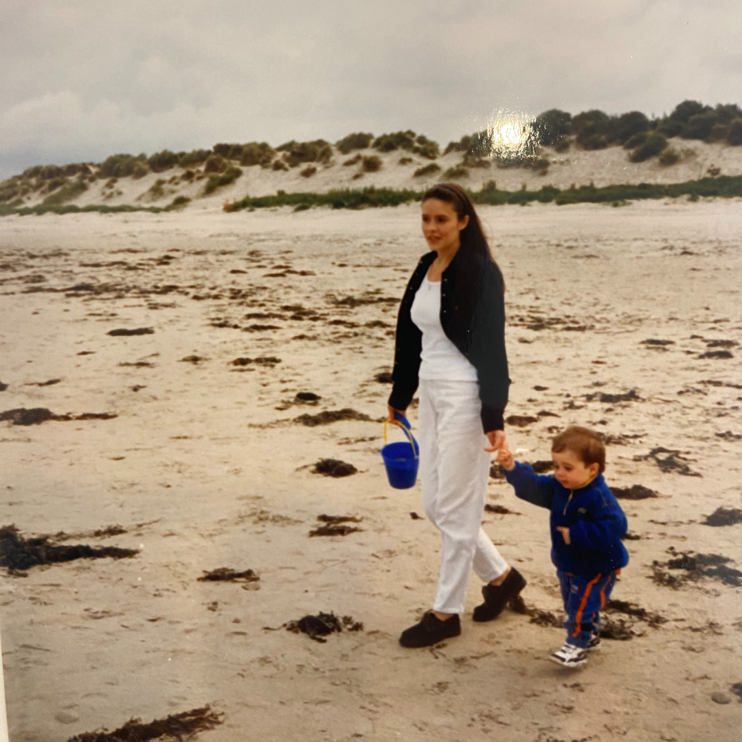 Old photograph of mother and son holding hands on the beach