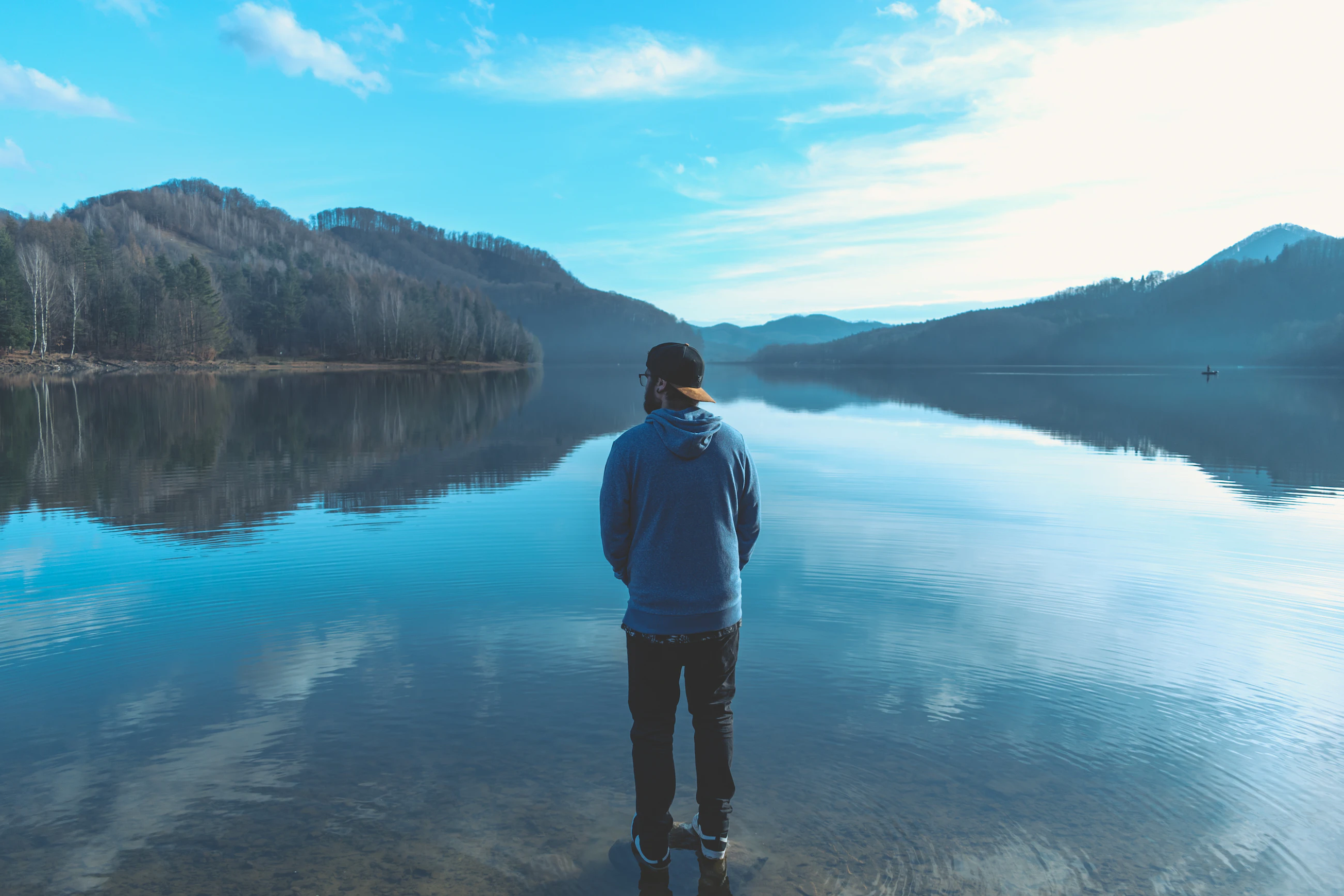 pic 3 man staring in to leg surrounded by scenic mountains