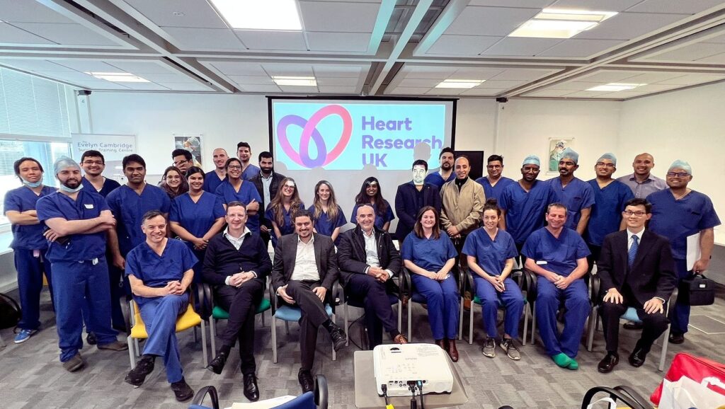 Large group of delegates in front of a screen showing the HRUK logo