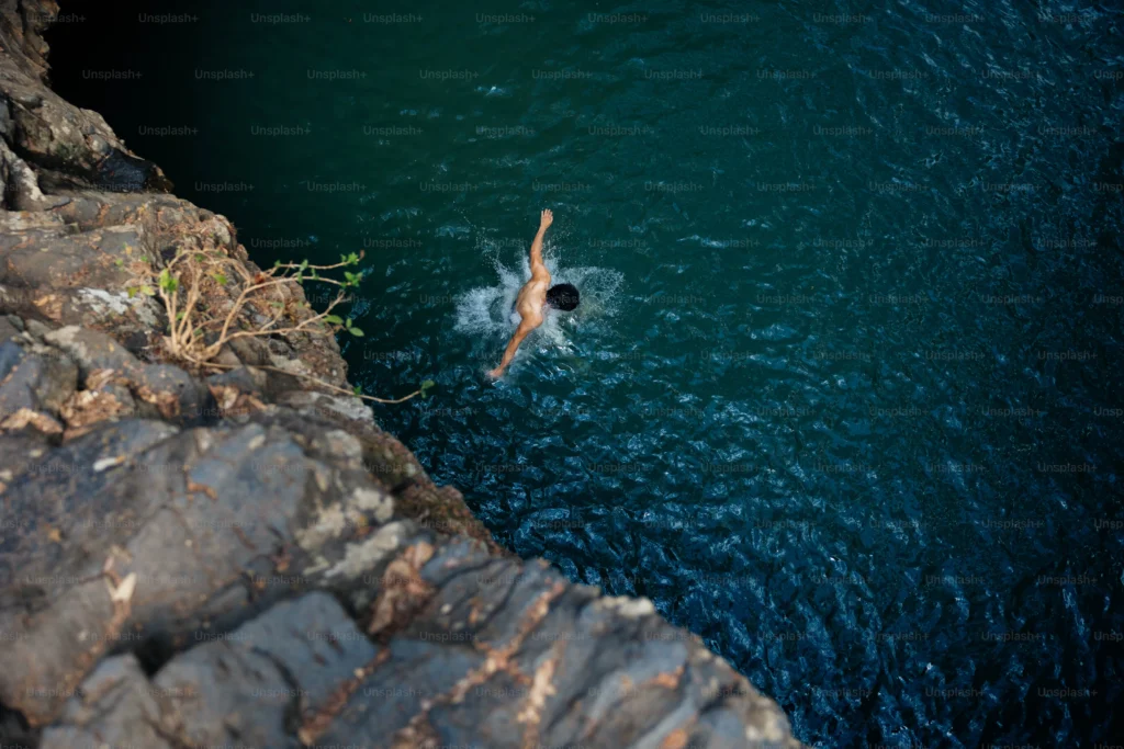 Person swimming in between rocks
