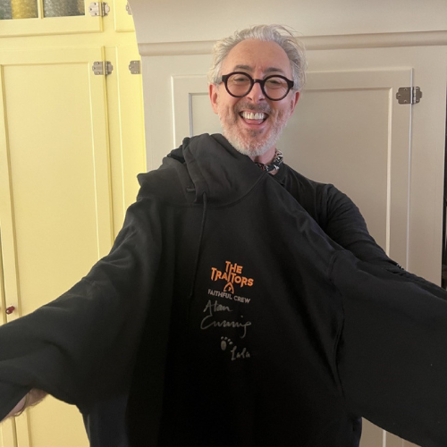 Untitled design (31) Alan Cumming holding a signed hoodie