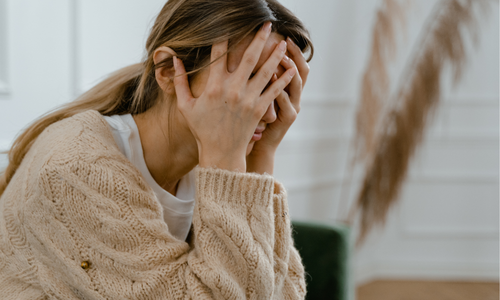 woman holding her head in hands in distress