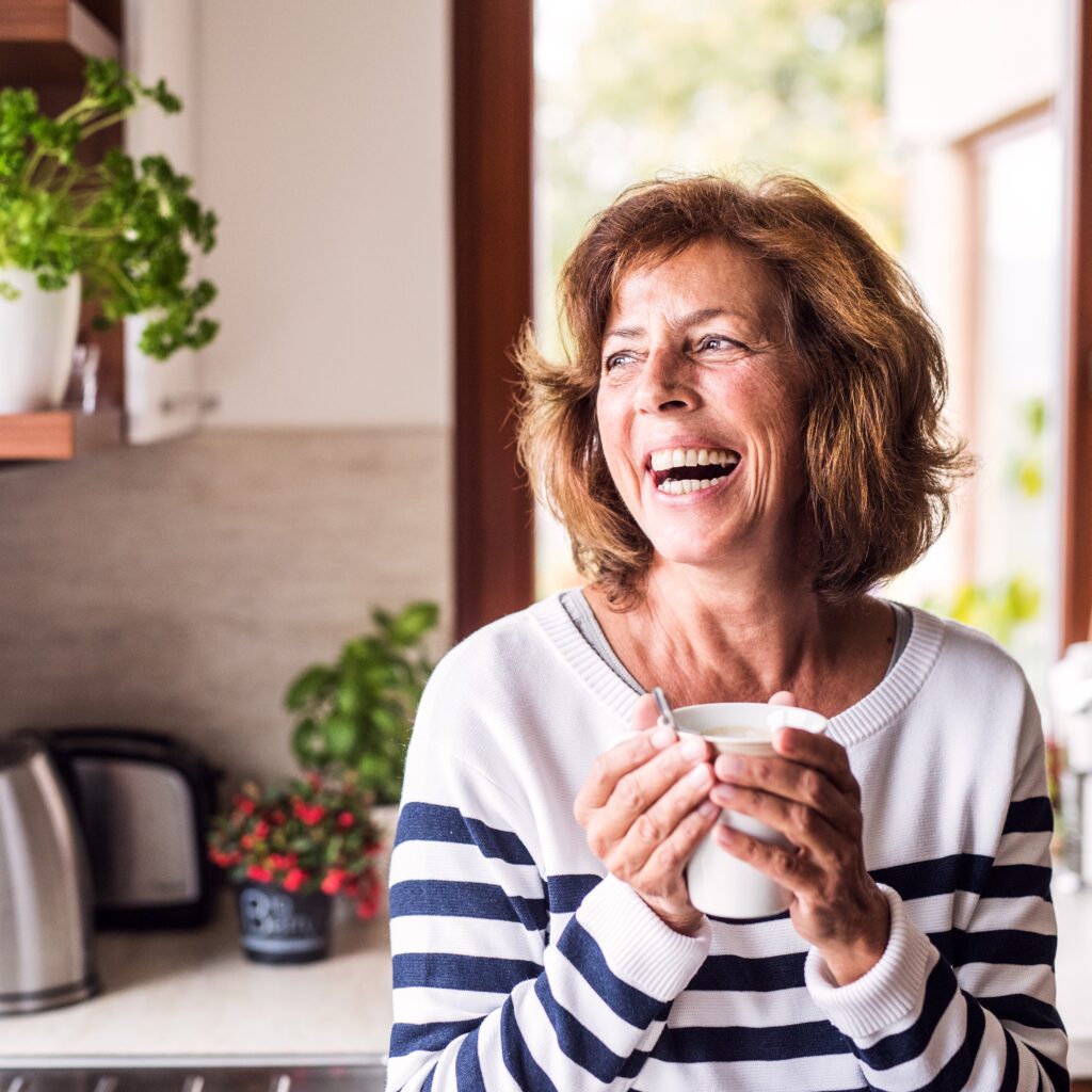 Woman smiling holding a mug