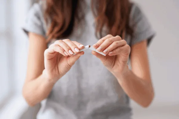 Woman breaking cigarette in two
